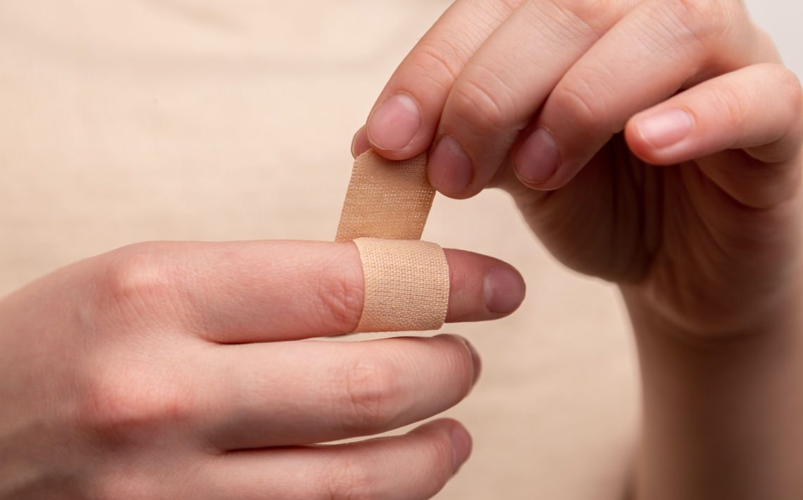 person with band aid on middle finger
